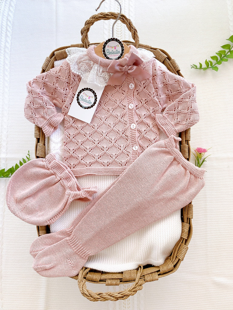 Tejido color rosa palo calado con botones al frente y encaje en el cuello con un moño rosa palo