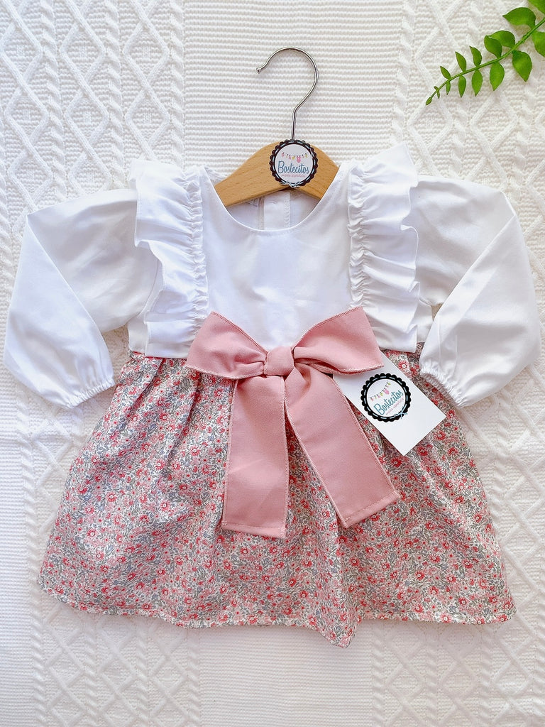Vestido manga larga mitad blanco y mitad estampado flores rosas con moño rosa grande en medio