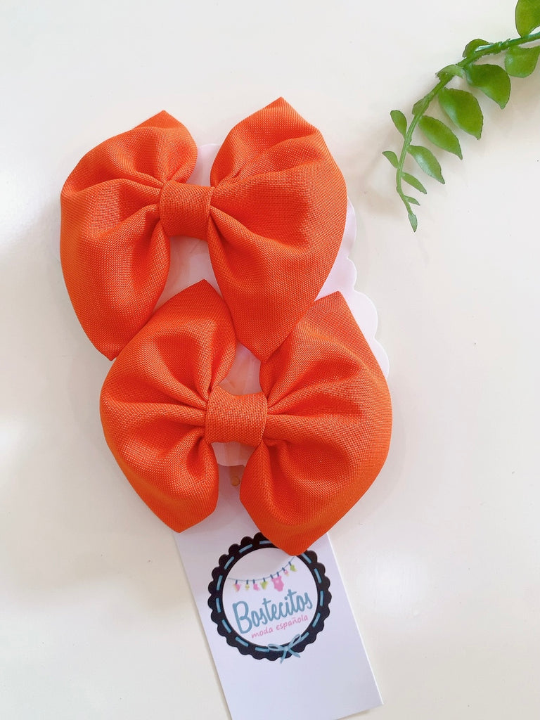 Par de moños color naranja para dos colitas