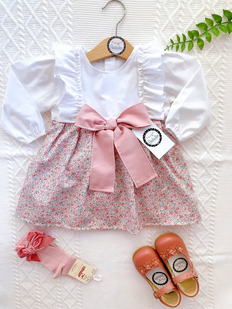 Vestido manga larga mitad blanco y mitad estampado flores rosas con moño rosa grande en medio