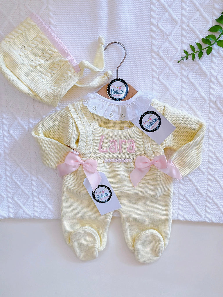 Mameluco tejido amarillo con dos moños rosas y gorro (1 mes)