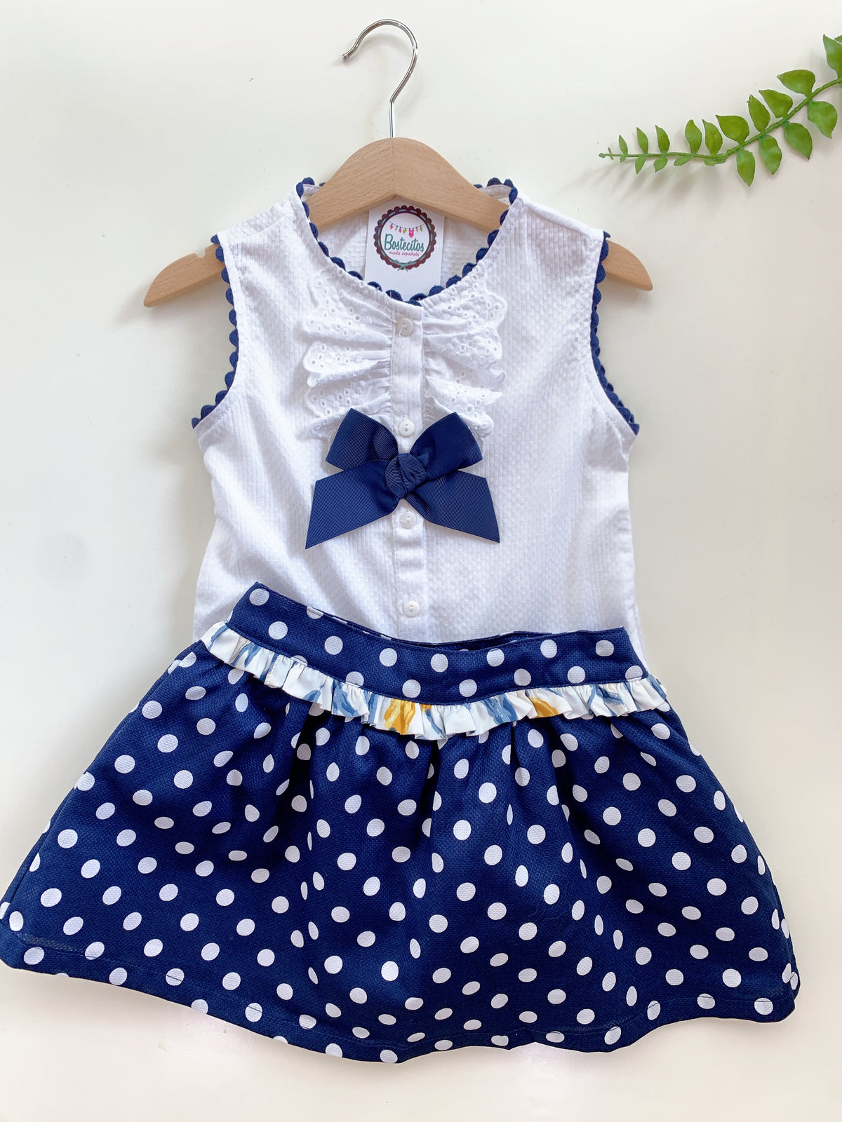 Conjunto falda azul marino con bolitas blancas y blusa blanca con mono